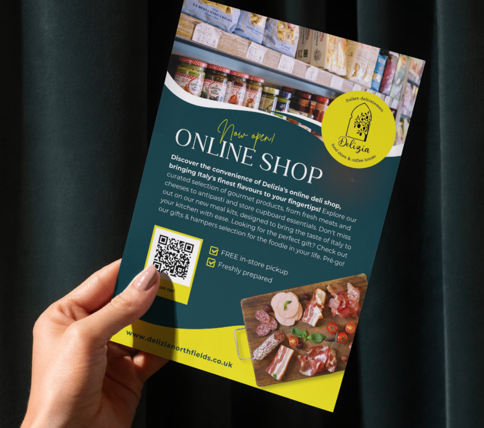 A hand holds a flyer designed for Delizia to promote their online deli shop