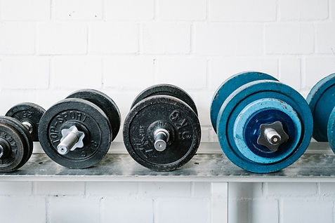 A number of dumbbells lined up in a gym. This image heads the Hungry4Fitness Training Equipment page. This page contains loads of blogs on the best training equipment on the market.