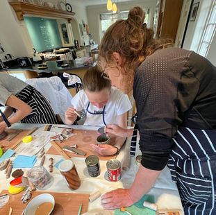 Group of people learning how to hand build a pottery platter at Wookey Hub in Somerset