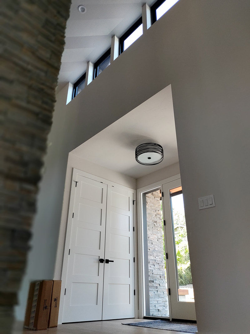Modern home entryway with double doors and stone accents