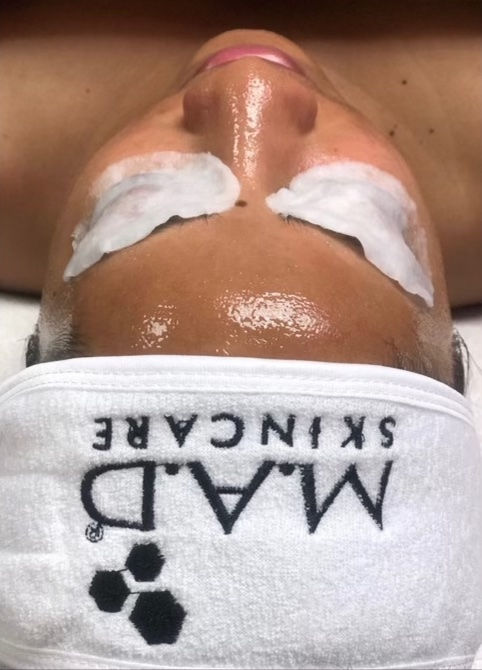 woman getting a facial with MAD skincare products