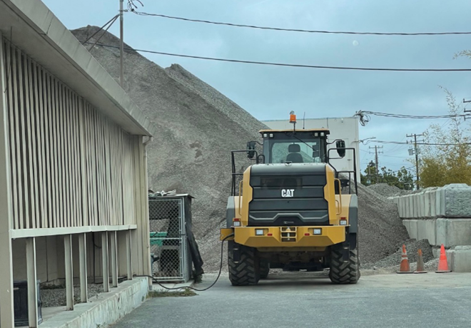 Argent Materials' all-electric CAT loader charging at their facility. Credit: Argent Materials