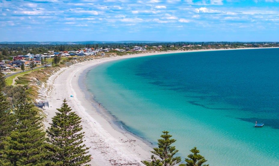 Aerial view of a curved sandy beach and ocean.