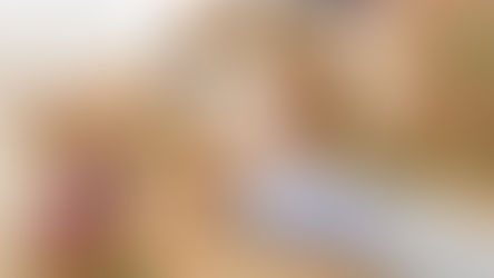 Zwei junge Menschen, die zwischen Umzugskartons am Boden liegen und sich anlächeln