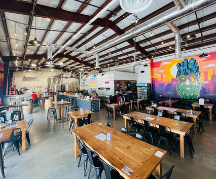 Spacious Sterling Street Brewery interior with tables, brewery equipment, and vibrant mural