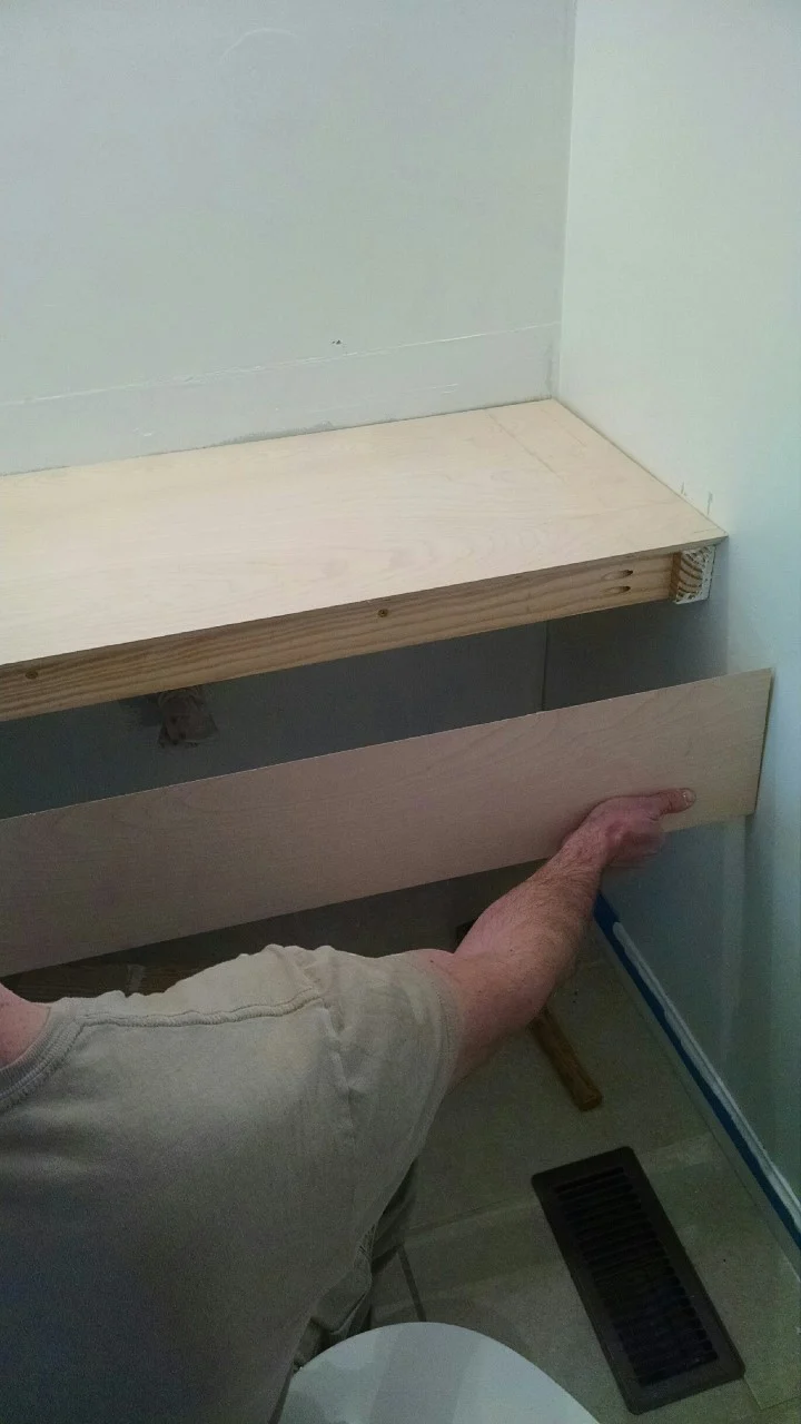 hand holding the front wood facing for floating vanity