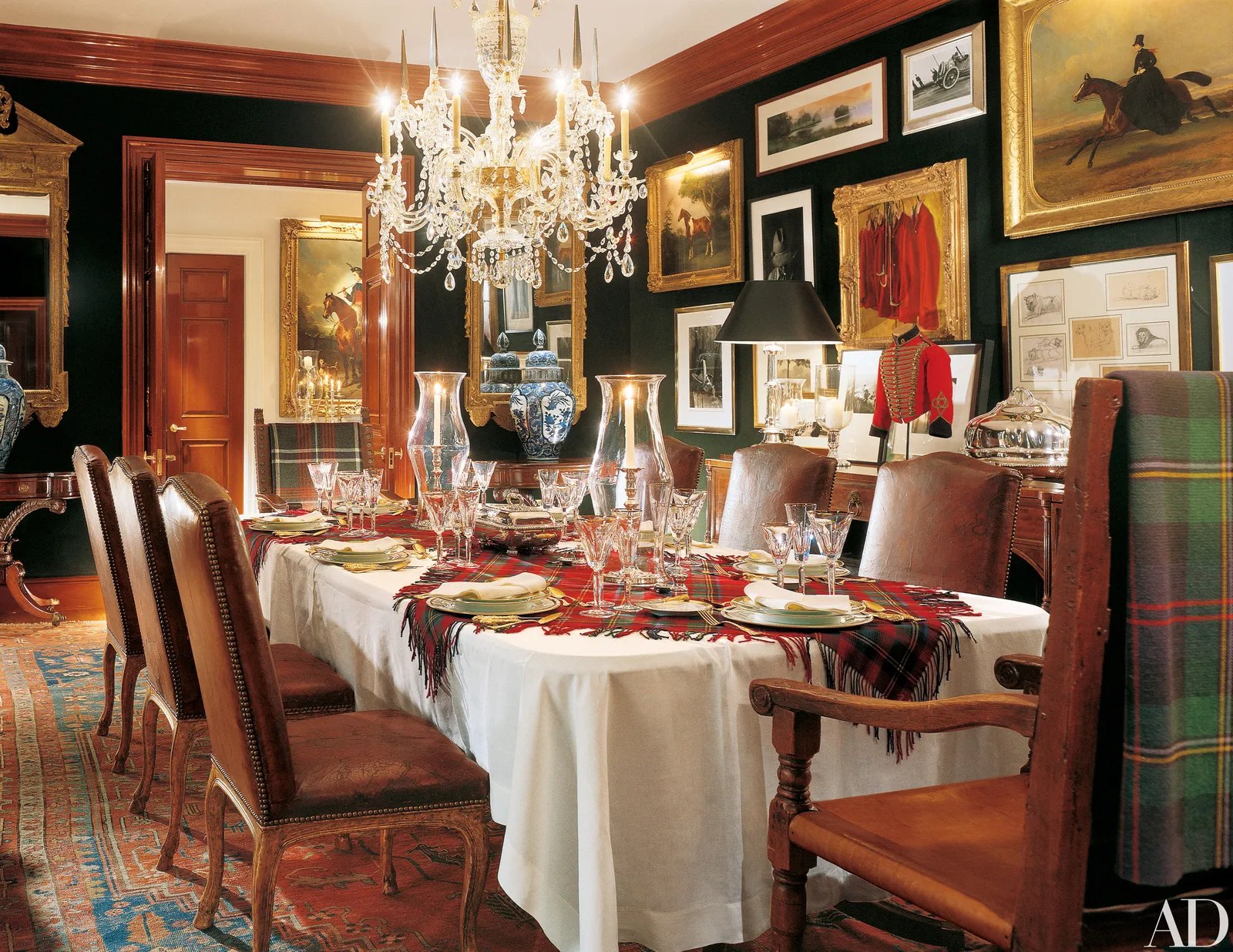 A luxurious timeless and elegant formal dining room with artwork, a crystal chandelier and linens on the table