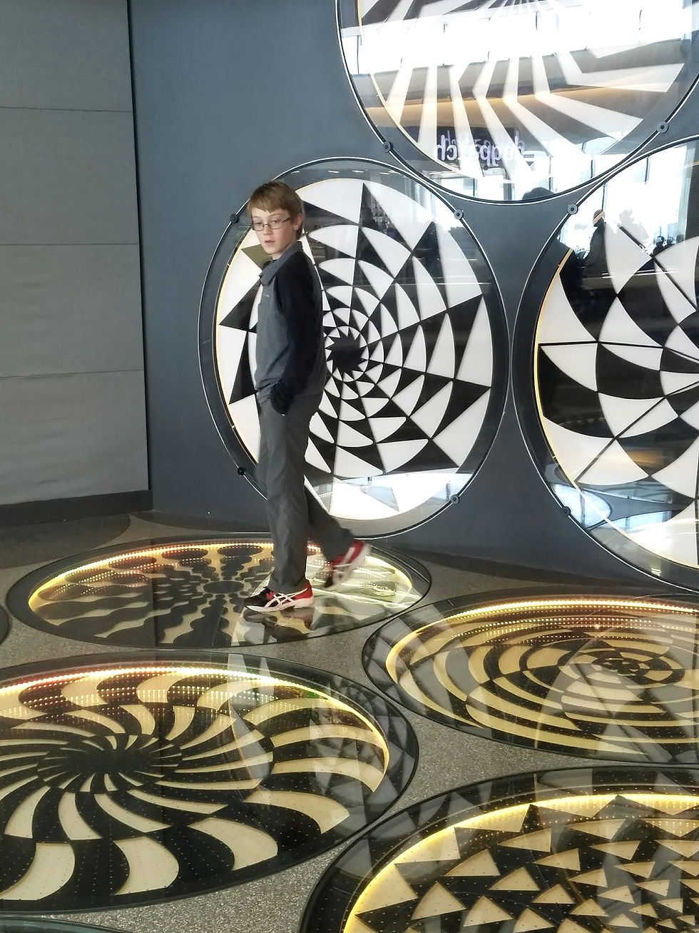 Child exploring a black-and-white art installation while traveling