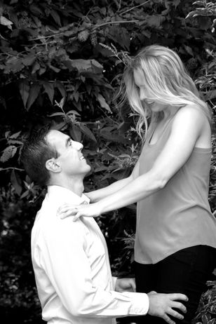 Man kneeling while proposing to his partner in a garden.