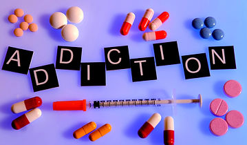 Word addiction surrounded by medication and syringe .jpg
