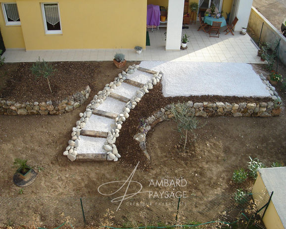 Emménagement d'un petit jardin avec dénivelé avec mur en pierres sèches et escalier en traverse de chemin de fer et plantations méditerranéenne Création AMBARD PAYSAGE