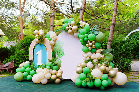 Photo zone in the park at a children's birthday party - green balloons form an arch with t
