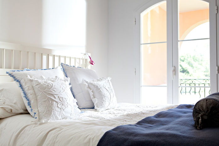 White Cushions with Blue Detail White Bedspread with Dark Blue Throw
