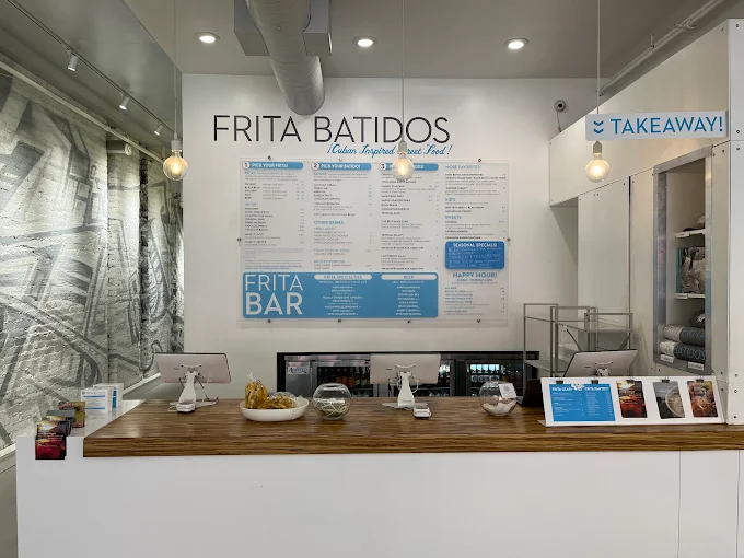 Interior of Frita Batidos restaurant in Ann Arbor, MI with Cuban-inspired menu displayed above the order counter