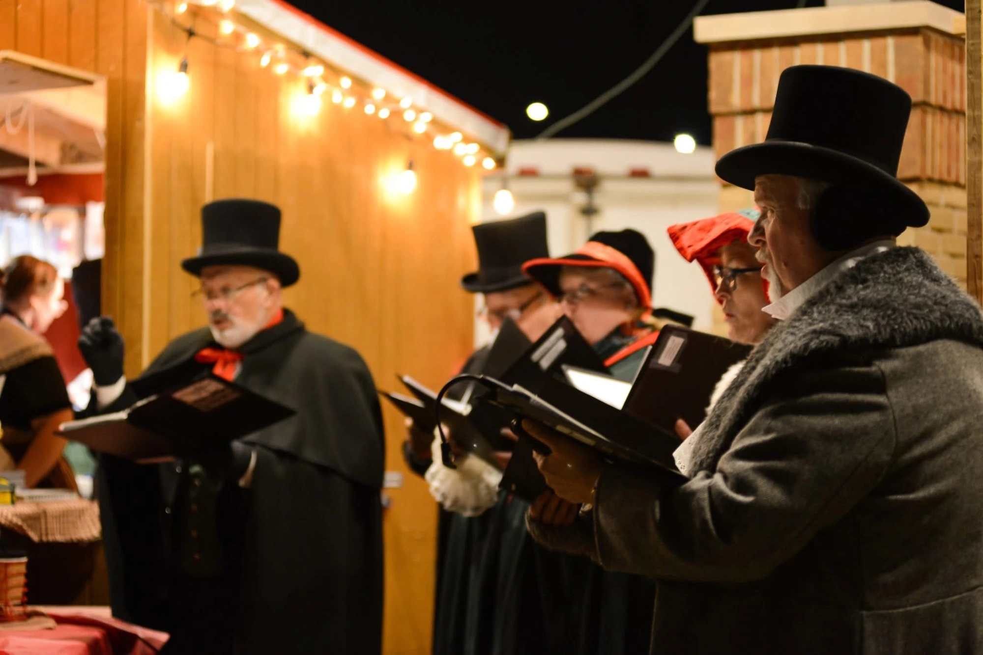 Christmas carolers performing at Kerstmarkt in Holland, MI, bringing festive music to the European-style outdoor holiday market.