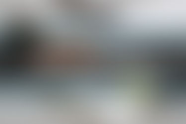 Overhead view of finance tracking sheets, paperwork, and budgeting documents on a gray table, with a pen and paperclips — representing real estate financial organization - thumbnail