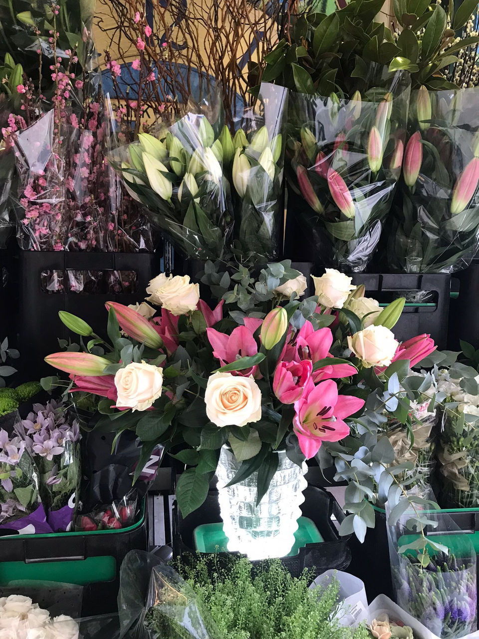 deep pink lillies, white roses, green foliage, Lalique vase