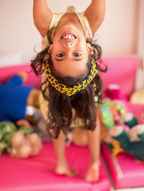 child-playing-upside-down-in-her-room.jp