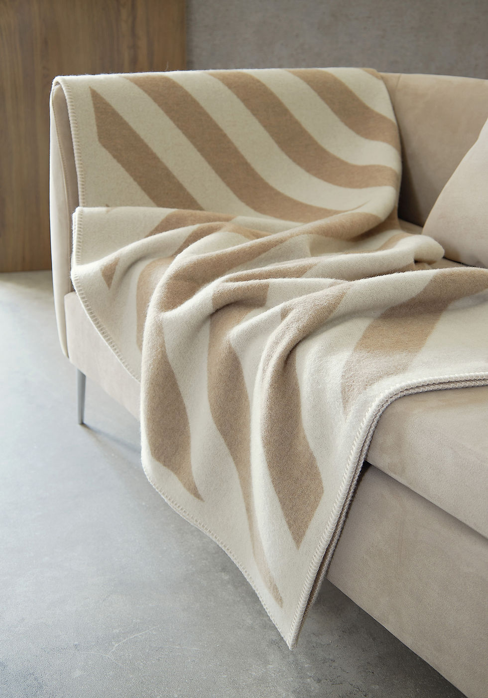 Nahaufnahme einer luxuriösen Kaschmirdecke in sanften Beige-Tönen