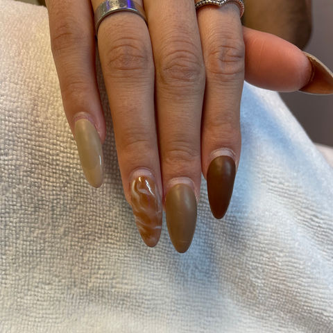 One hand showing light and darker brown gel polish manicure from Keeping It Cute Salon & Spa