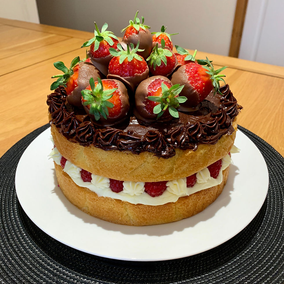 A vanilla sponge cake topped with chocolate strawberries