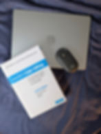 Laptop, book titled "Butcher's Copy-editing," and a mouse on a dark blue fabric surface. The setting feels organized and focused.