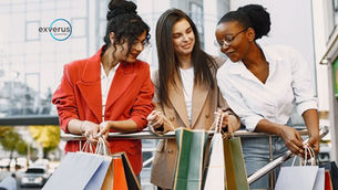 Three women with shopping bags lean on a railing in a city; exverus logo at top left, smiling and chatting.