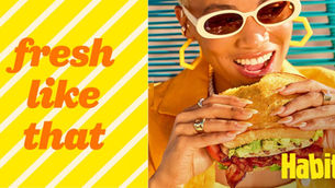 woman in sunglasses holding chicken sandwich