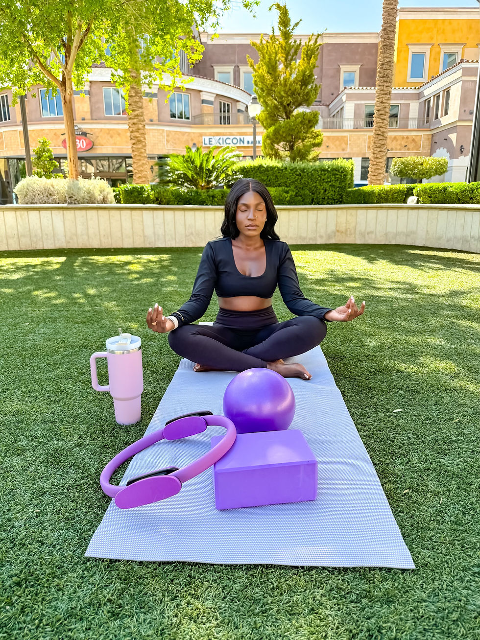 Woman meditating on yoga mat outdoors, surrounded by purple fitness gear. Sunny day with buildings and greenery in the background. benefits of pilates