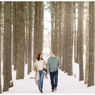 couple walking in fresh snow in the woods
