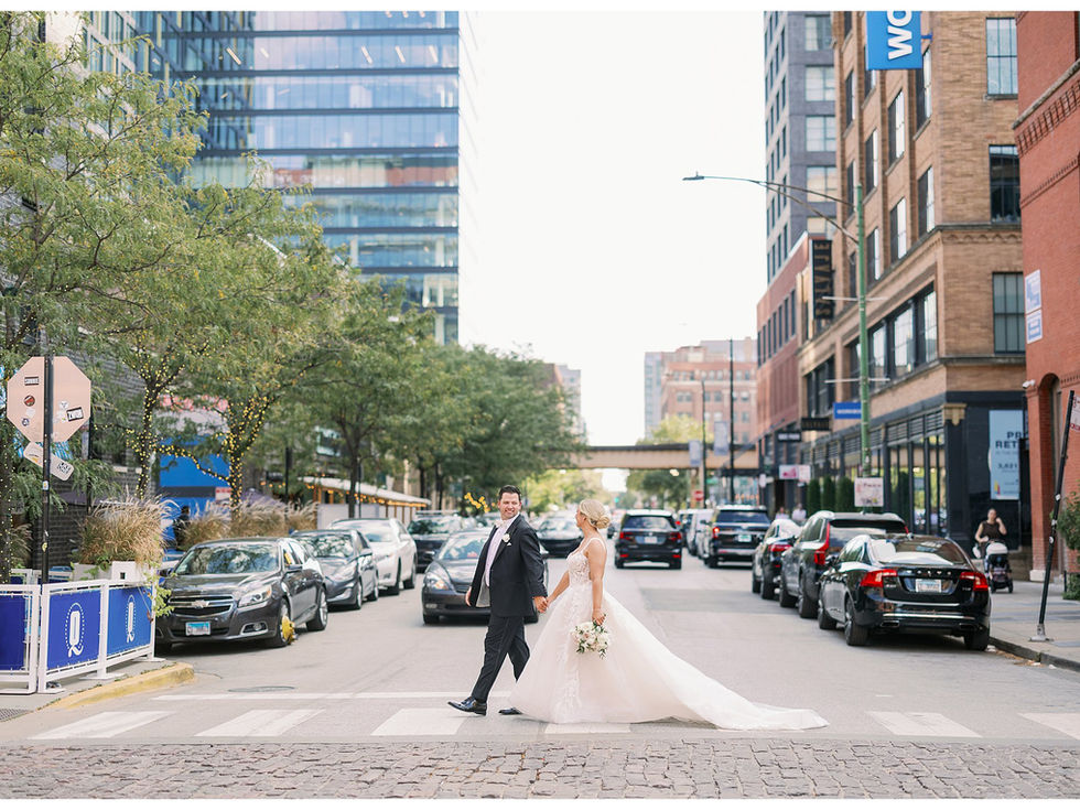 bride and groom walking in crosswalk in Chicago