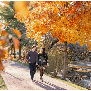 engaged couple smiling in front of the river