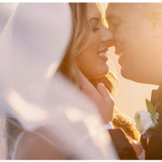bride and groom kissing by veil