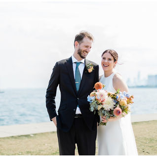 Bride and groom smiling together in front of Lake Michigan