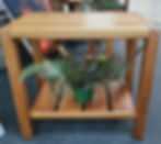 Wooden table with a potted plant on the shelf; home decor.