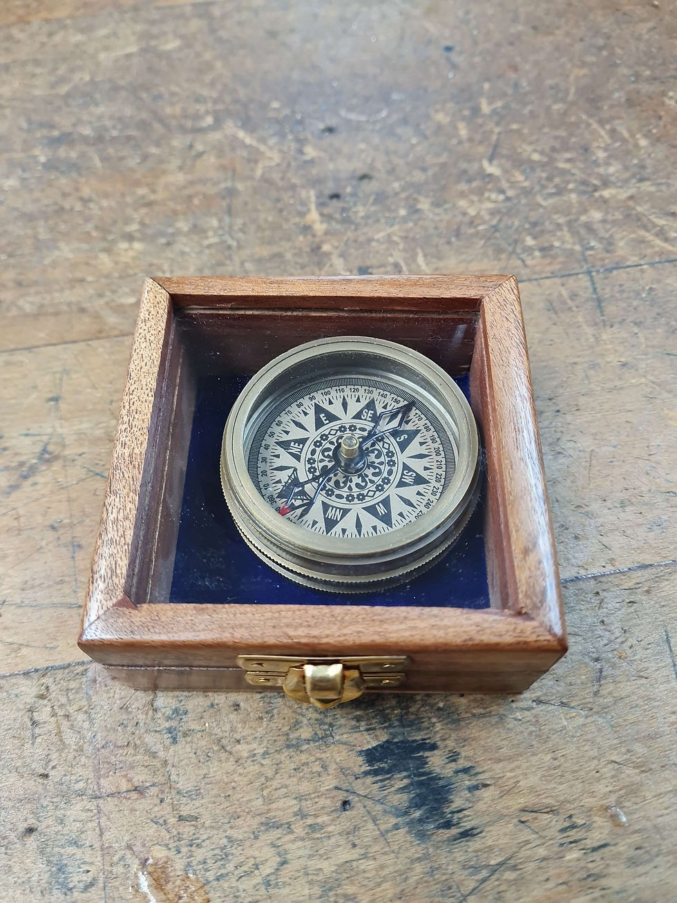 compass in a brown wood box with a glass lid