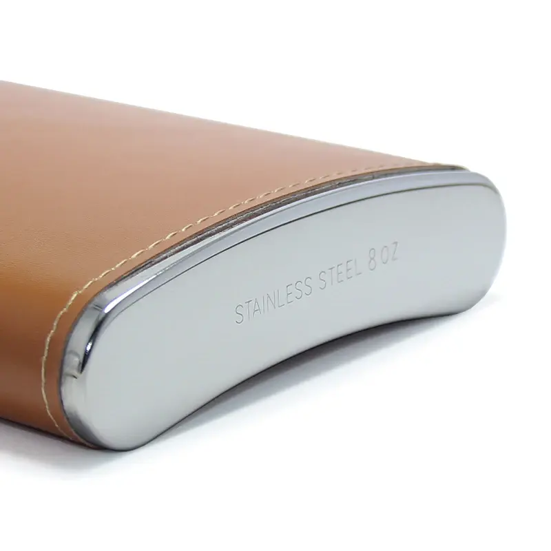 Thumbnail: Close-up of a tan leather flask with text BACKCOUNTRY GIFTS on it.
