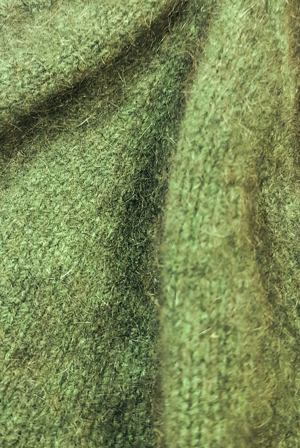 Thumbnail: Close-up of a soft green knitted fabric, highlighting texture and detail.