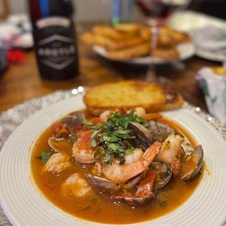 plated cioppino with basil garnish and toasted bread