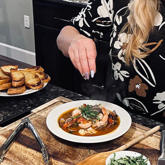 adding basil garnish to cioppino