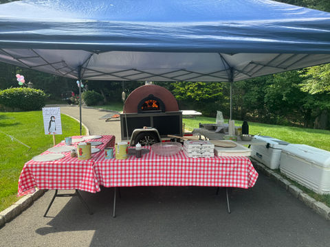 Photo of a pizza oven trailer with tables and a tent  | Little Mozz | Wood Fired Pizza Trailer | Catering for Private Parties and Corporate Events in Westchester County, New York and Fairfield County, Connecticut