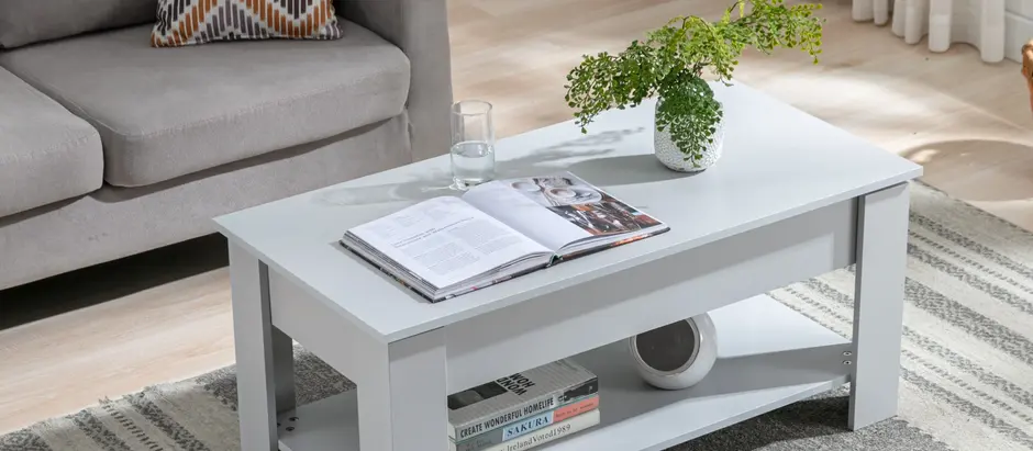 Modern light grey coloured storage coffee table with an open shelf in a cozy, sunlit living room.
