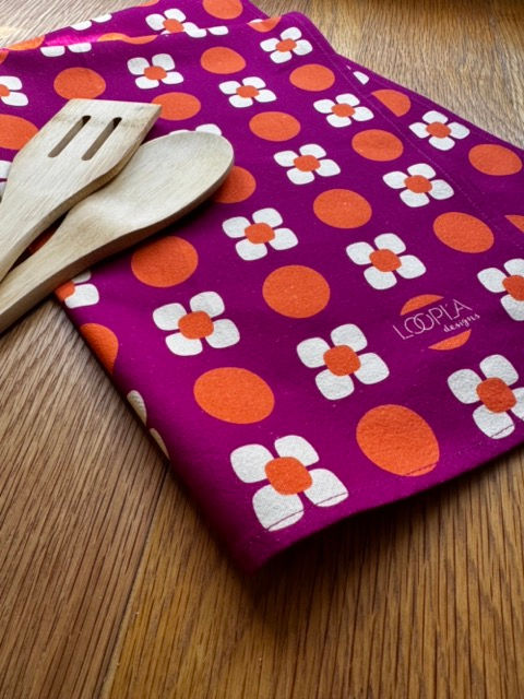 Loopla Daisy Spot pattern tea towel in 100% cotton crepe, styled with a wooden spoon. Hand-designed by a Brisbane surface d