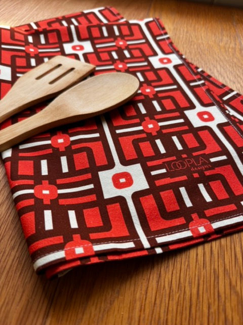 Loopla Lattice Love pattern tea towel in 100% cotton crepe, styled with a wooden spoon. Hand-designed by a Brisbane surface d