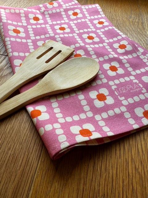 Loopla Daisy Check pattern tea towel in 100% cotton crepe, styled with a wooden spoon. Hand-designed by a Brisbane surface d