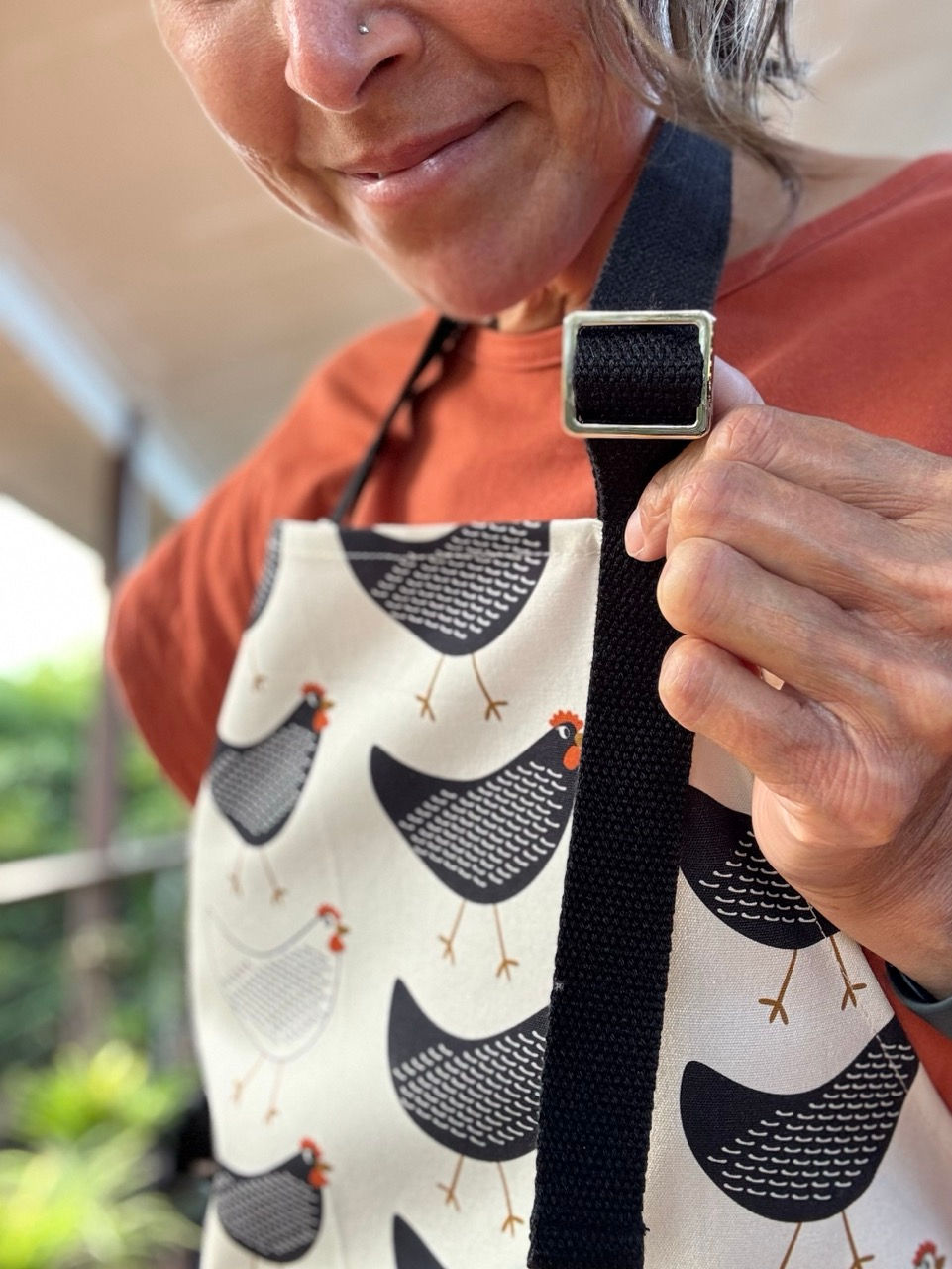 Close-up of the metal adjustable slider buckle on the neck strap of the Chick Chick Chicken cotton apron.