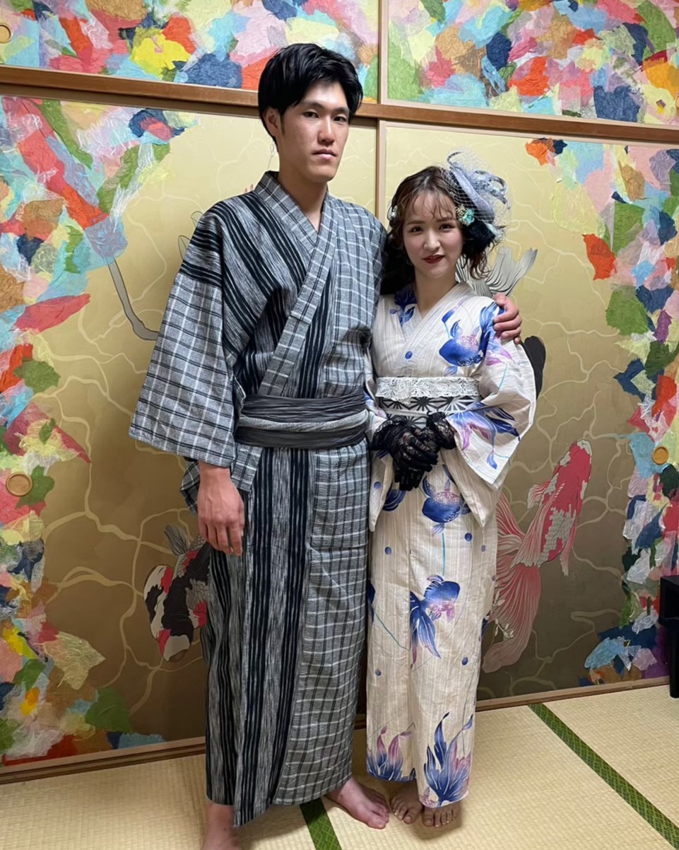 華やかな襖の前で浴衣を着て並ぶ男女