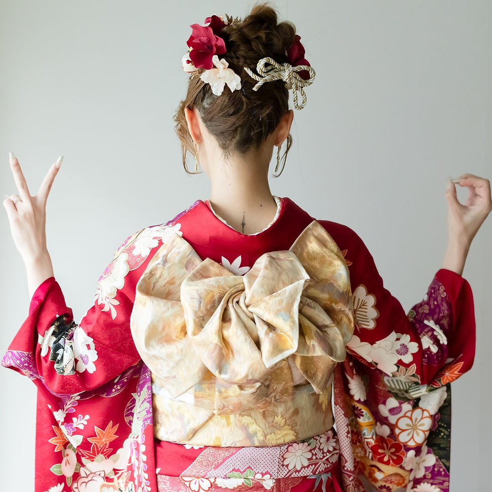 赤い振袖を着用し、華やかな帯結びをした女性の後ろ姿