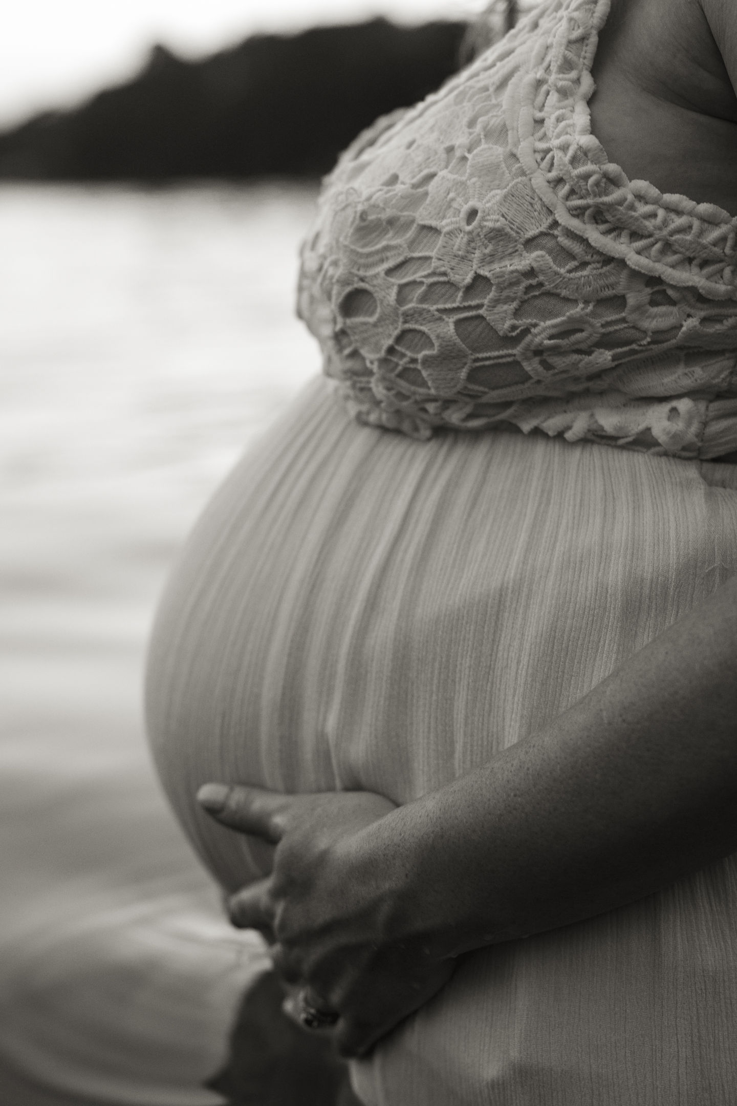 Profile of just baby bump being cradled in lake. 