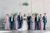 Full wedding party portrait – elegant urban venue backdrop for modern all-inclusive wedding photography.